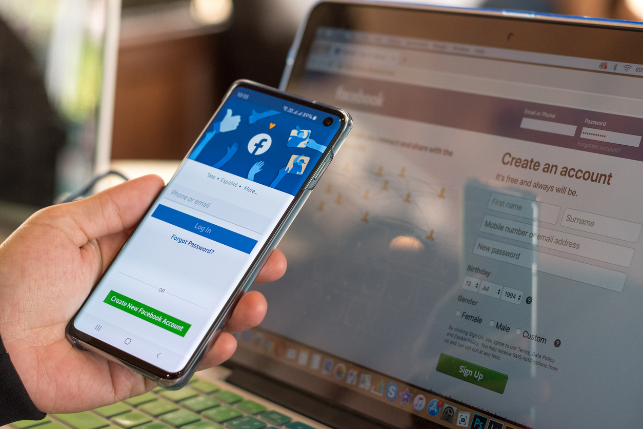 Facebook signup web page app on smart phone Samsung Galaxy S10 with user sign in registration screen using social networking and computer notebook from anywhere office.