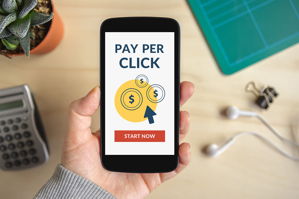 Hand holding smart phone with Pay Per Click concept on screen